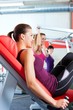Beschreibung: Frauen machen Krafttraining im Fitnessstudio